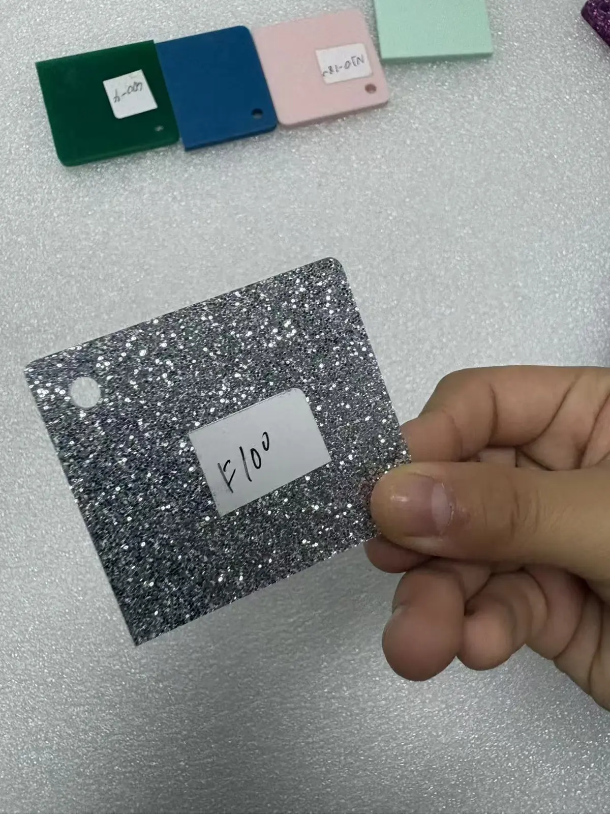 Silver glitter acrylic swatch held in hand