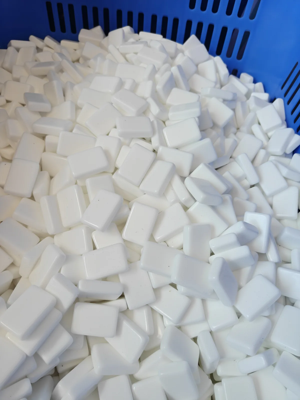 White acrylic Mahjong tile blanks in a production basket